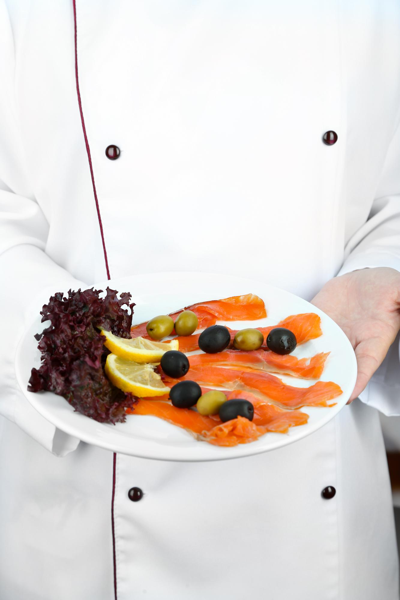 Chef presenting plated dish to students in workshop